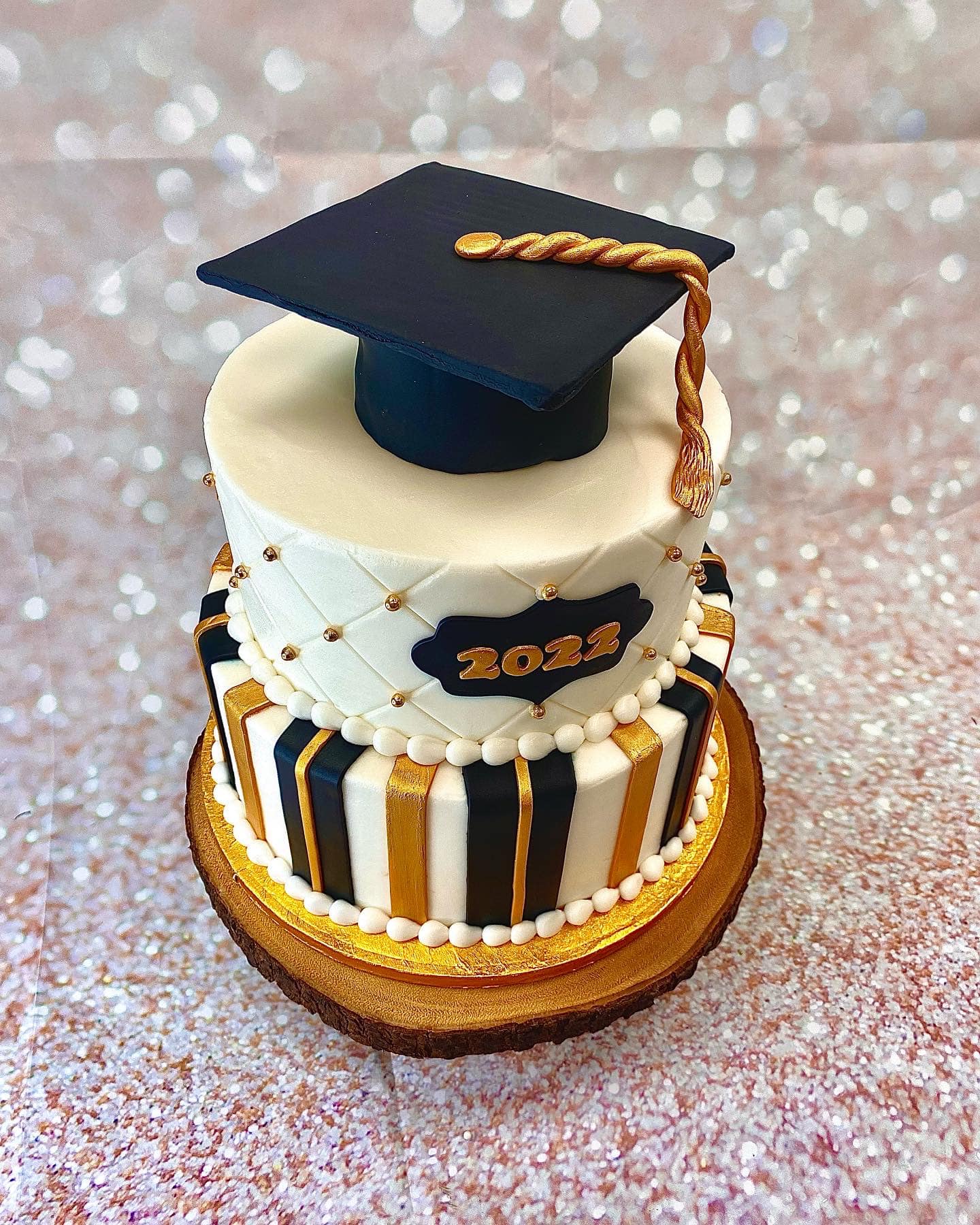 two tier graduation cake with graduation cap on top