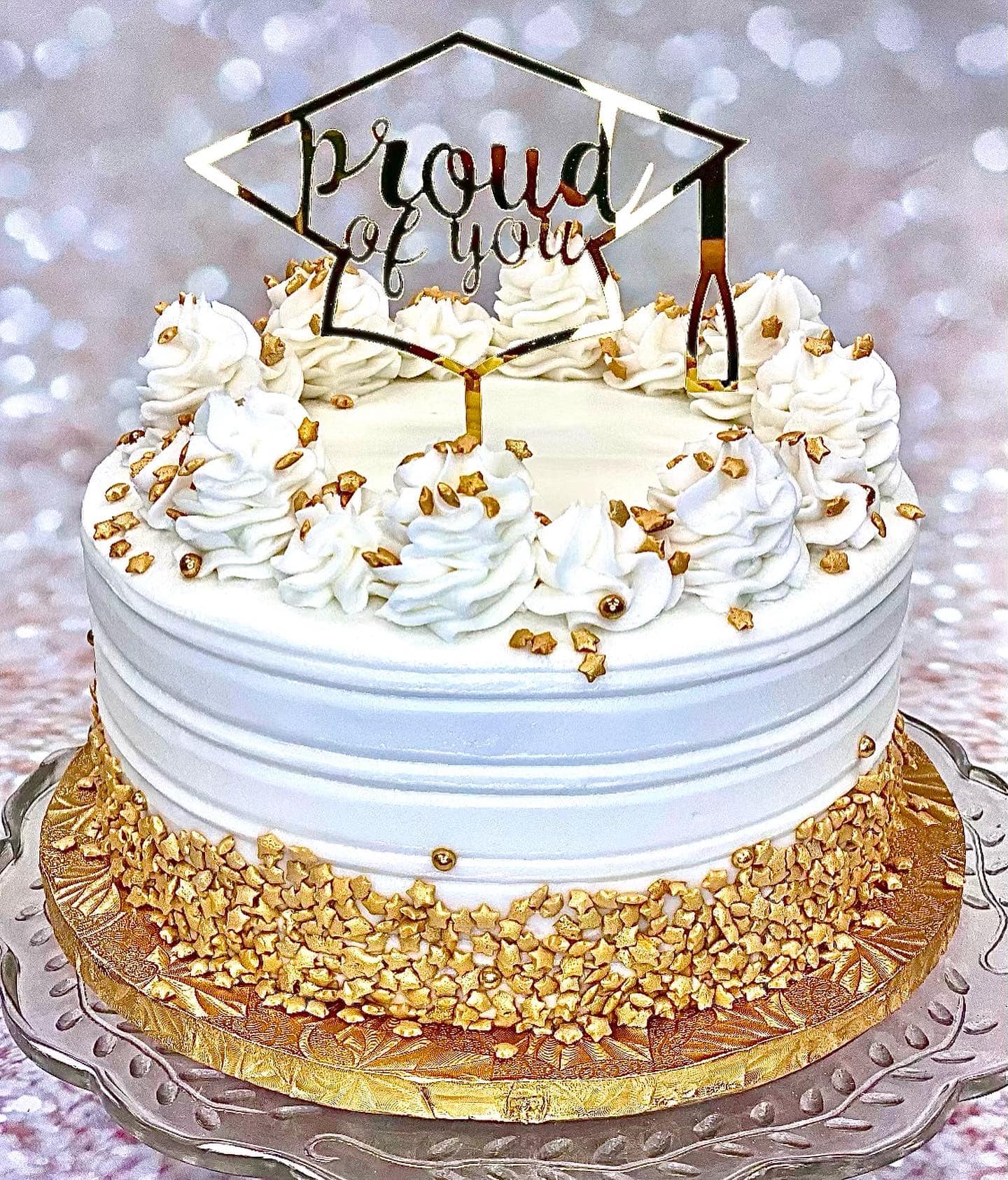 white and gold graduation cake with gold star sprinkles