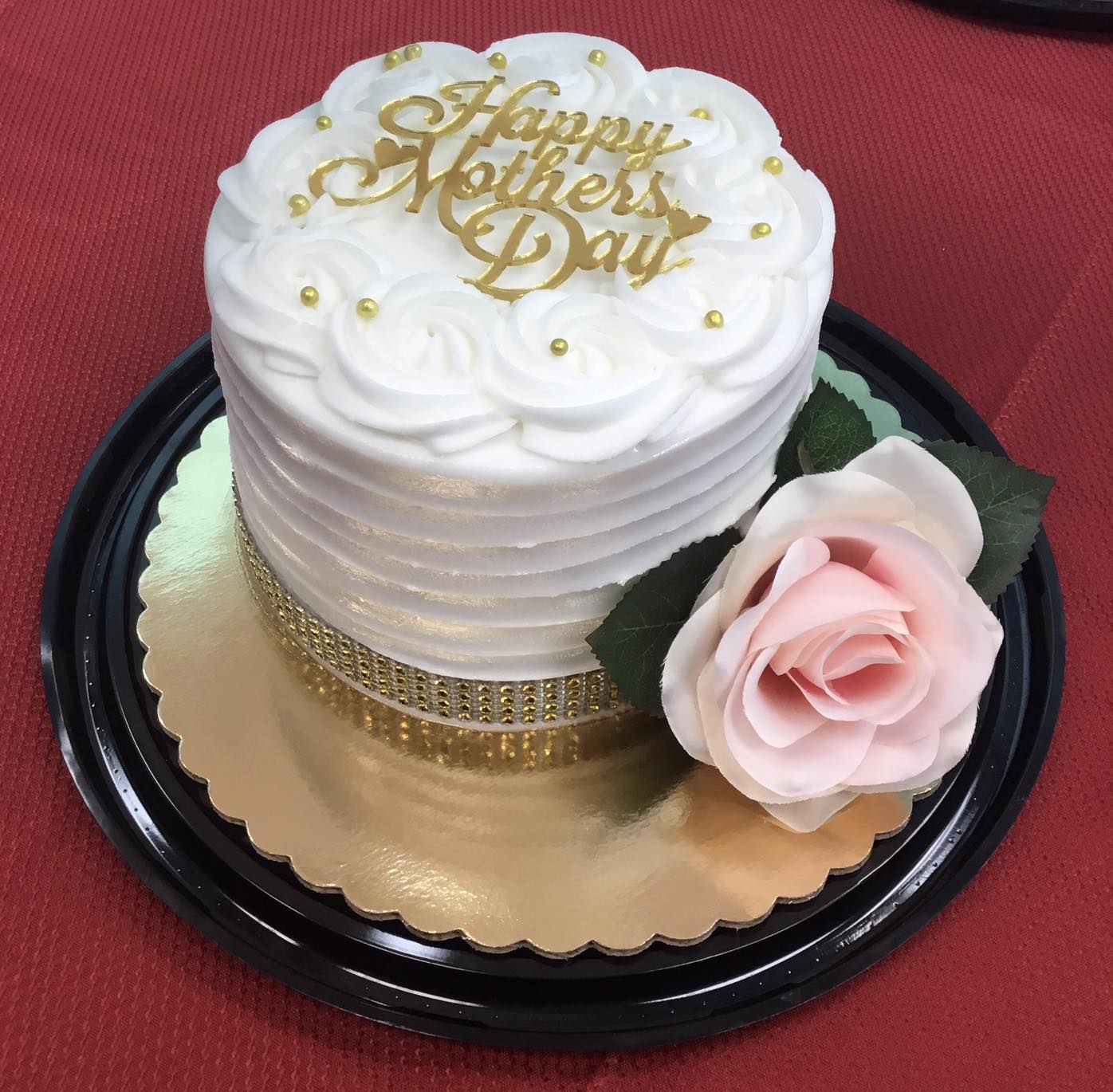 white and gold Mother's Day cake with pink flower